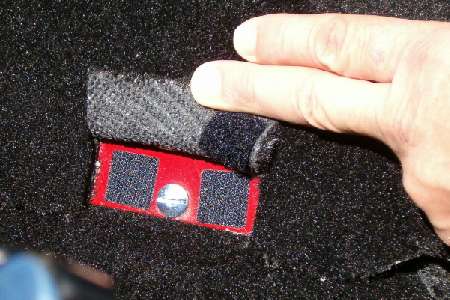 Velcro flap in carpet for battery cover fastener